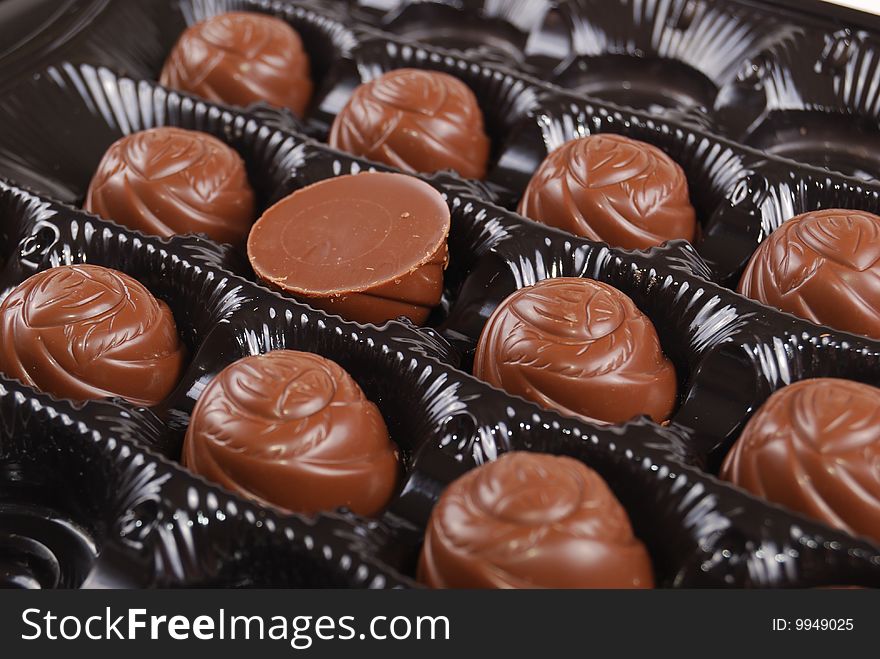 Chocolates in a box of black colour. A dessert.