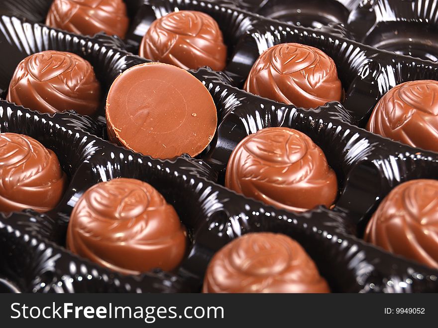 Chocolates in a box of black colour. A dessert.