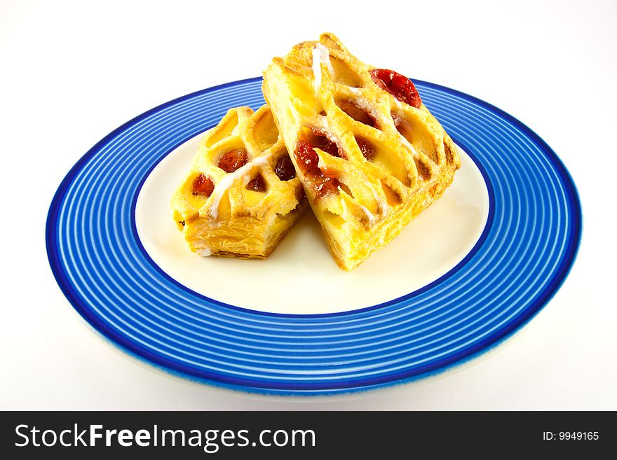 Raspberry and custard danish on a blue and white plate on a white background. Raspberry and custard danish on a blue and white plate on a white background