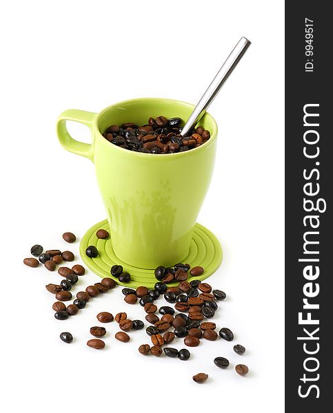 Green mug filled with coffee beans and a spoon. Green mug filled with coffee beans and a spoon