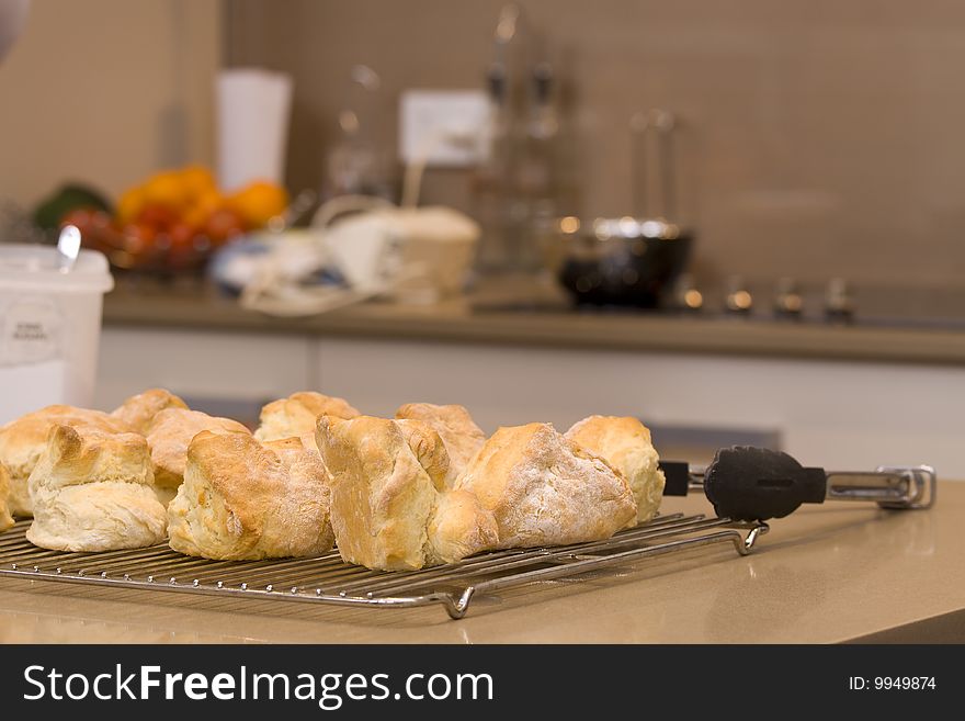 Scones that have just cam out of the oven, ready after being baked, with the cooking utensils in the background. Scones that have just cam out of the oven, ready after being baked, with the cooking utensils in the background.