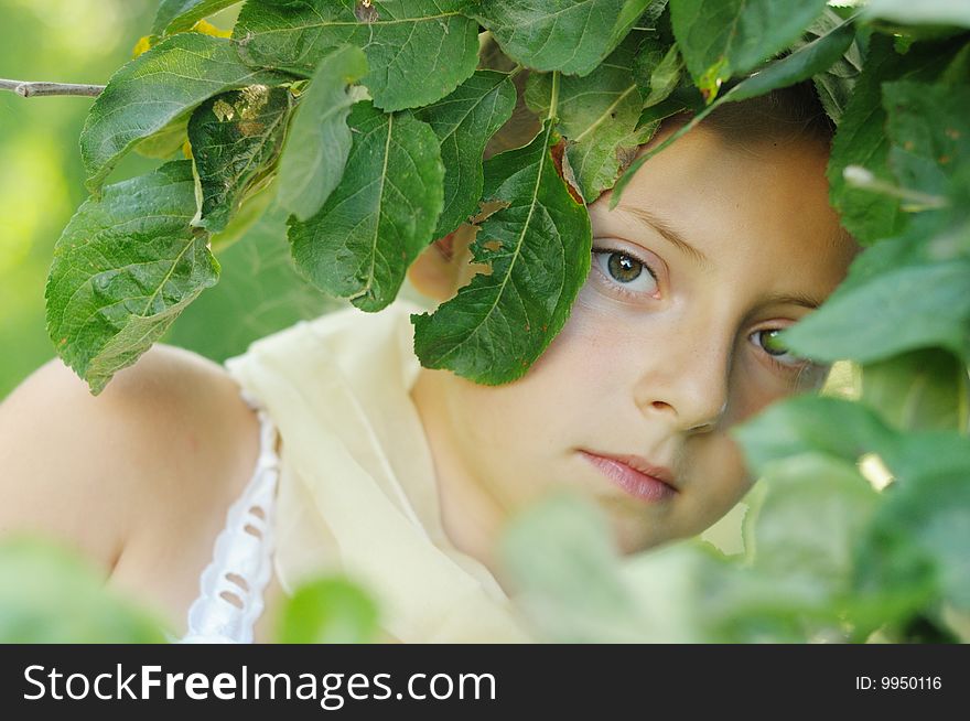 The girl looks out because of summer foliage. The girl looks out because of summer foliage