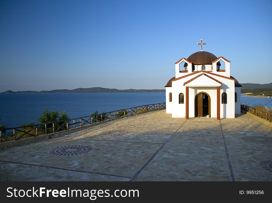 Afternoon shot of a white chapel with panoramic view to the sea