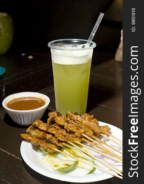 Chicken satay with peanut sauce and sugar cane drink ready for serving. Chicken satay with peanut sauce and sugar cane drink ready for serving.