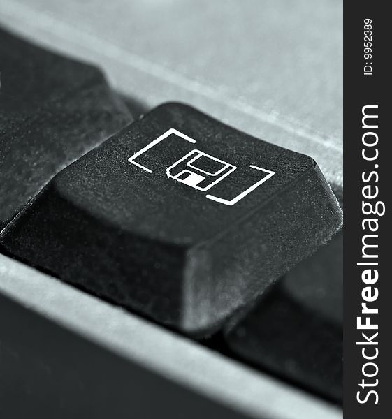 Button on keyboard with disc sign, black on metallic, angled. Button on keyboard with disc sign, black on metallic, angled