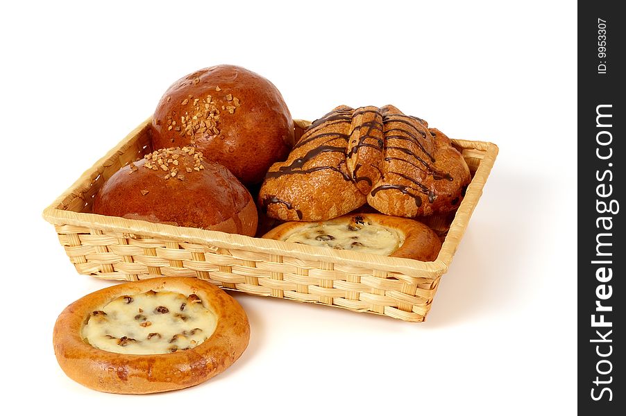 There are different types of pastry in the basket. With roasted peanuts, raisins, cottage cheese ad chocolate glaze. Isolated on white background. There are different types of pastry in the basket. With roasted peanuts, raisins, cottage cheese ad chocolate glaze. Isolated on white background.