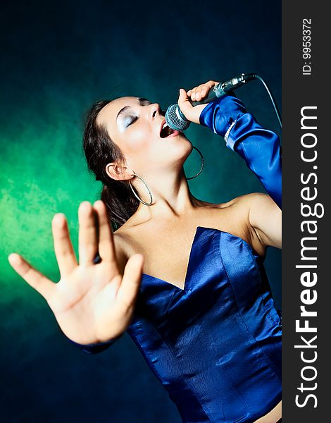 Sexy young woman singing with a microphone. Sexy young woman singing with a microphone