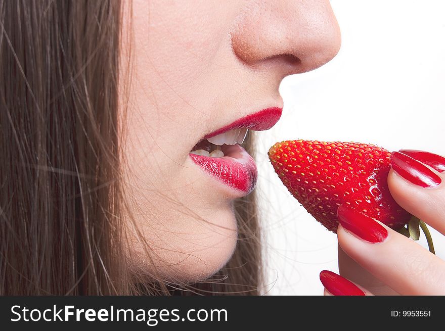 A young lady is tasteing a strawberry. A young lady is tasteing a strawberry