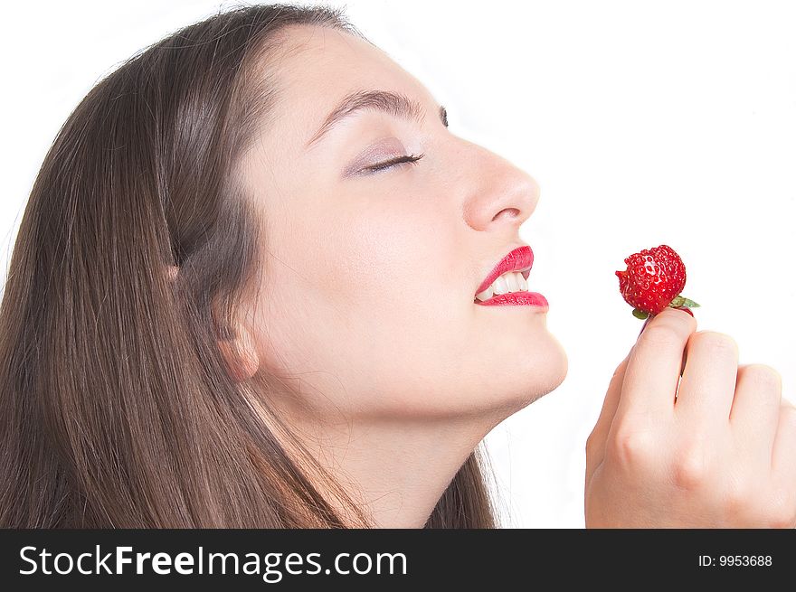 A young lady is tasteing a strawberry. A young lady is tasteing a strawberry