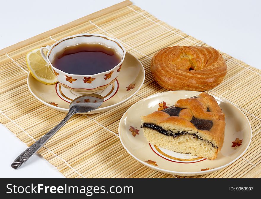 This picture depicts a cup of tea with lemon and pastry. This picture depicts a cup of tea with lemon and pastry