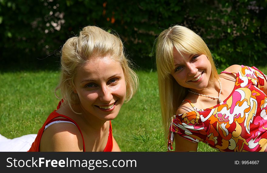 Two smiling blonde woman in summer