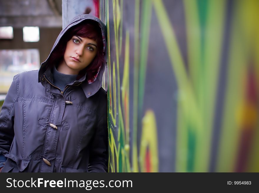 Girl posing by the graffiti wall in a jacket. Girl posing by the graffiti wall in a jacket