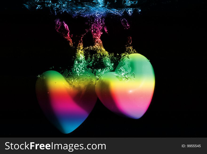 Colorful Hearts splashing underwater against black background. Colorful Hearts splashing underwater against black background