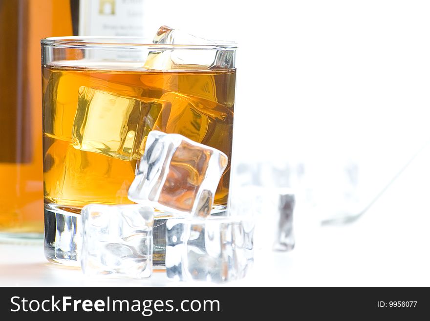 Alcoholic beverage whith ice cubes isolated over white