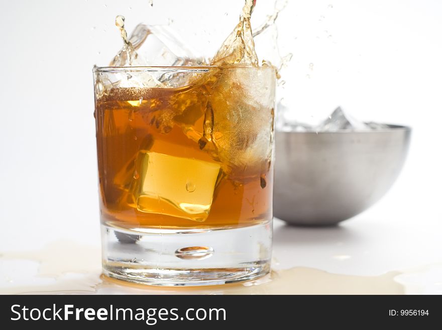 Alcoholic beverage whith ice cubes isolated over white