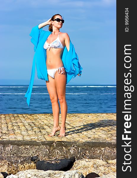 Girl in blue transparent cloth standing on the beach. Girl in blue transparent cloth standing on the beach