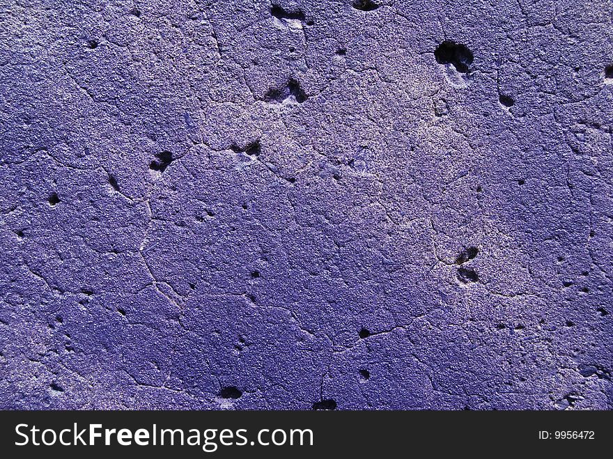 Close-up view of a purple graffiti painted on a concrete wall. Close-up view of a purple graffiti painted on a concrete wall