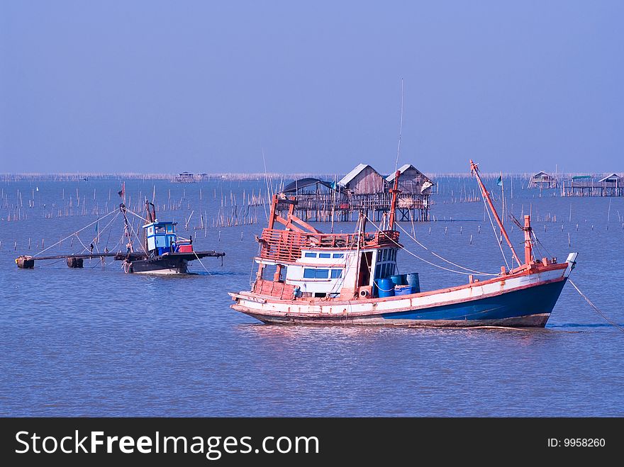 Two blue and orange fishing boats anchored in the Gulf of Siam, in the harbour of Chonburi City. Two blue and orange fishing boats anchored in the Gulf of Siam, in the harbour of Chonburi City.