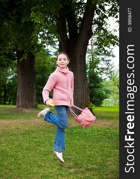 Girl jumps on a green grass against trees. Girl jumps on a green grass against trees