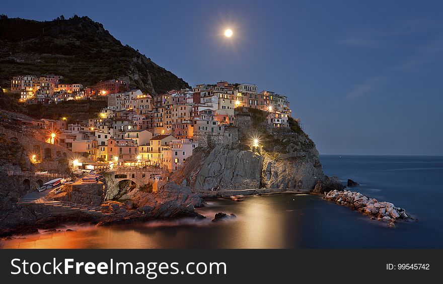 Coastal town on hillside illuminated at night with moonlight. Coastal town on hillside illuminated at night with moonlight.