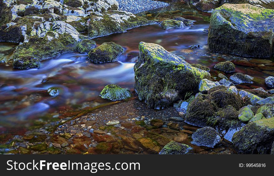 Blur of water over moss covered rocks in small stream. Blur of water over moss covered rocks in small stream.