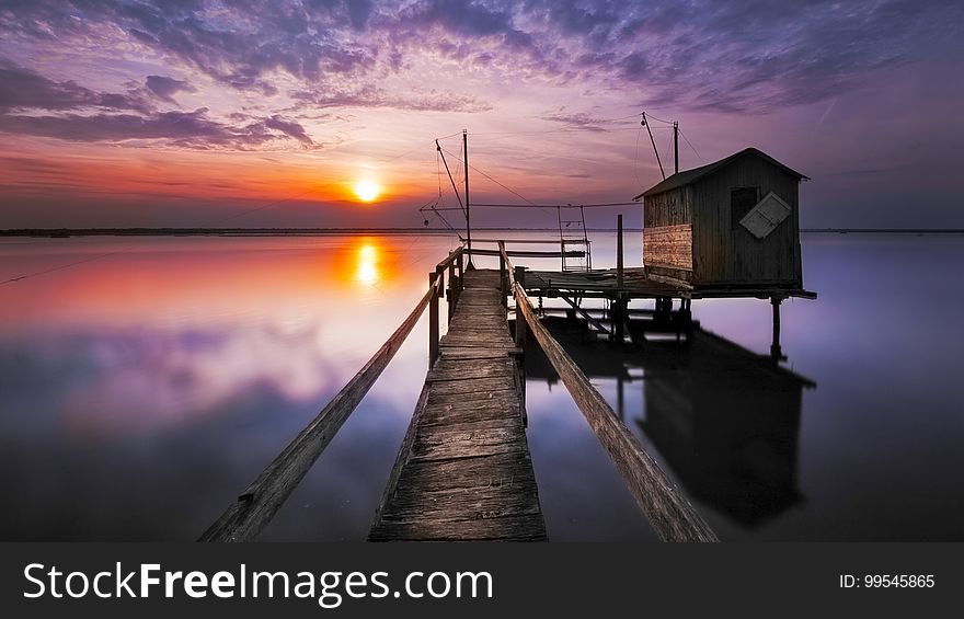 Sunset on the sea with a wooden pier and a boathouse. Sunset on the sea with a wooden pier and a boathouse.