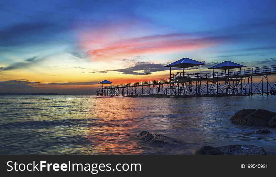 A pier in the sea at sunset. A pier in the sea at sunset.