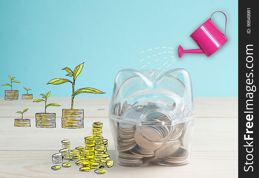 Transparent see through piggy bank filled with coins on wood background.Saving investment colorful concept. Transparent see through piggy bank filled with coins on wood background.Saving investment colorful concept.