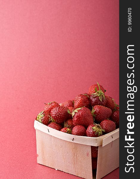 Wooden quart of ripe strawberries on a solid background. Wooden quart of ripe strawberries on a solid background