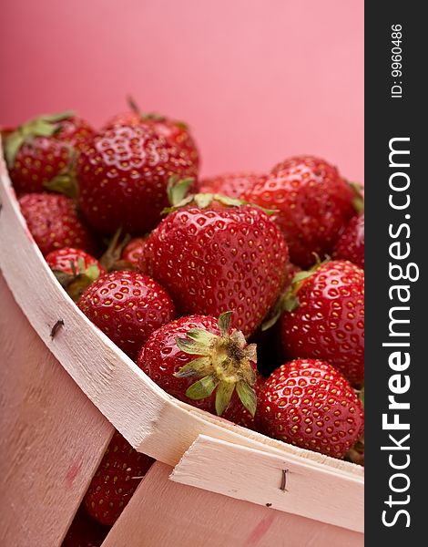 Wooden quart of ripe strawberries on a solid background. Wooden quart of ripe strawberries on a solid background