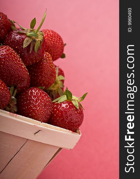 Wooden quart of ripe strawberries on a solid background. Wooden quart of ripe strawberries on a solid background