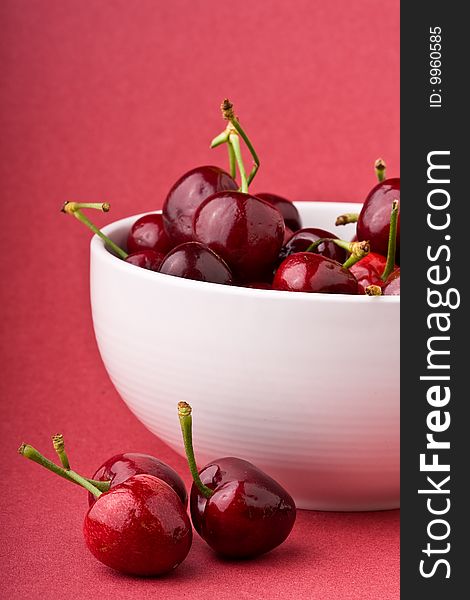 White bowlful of red cherries solid background. White bowlful of red cherries solid background