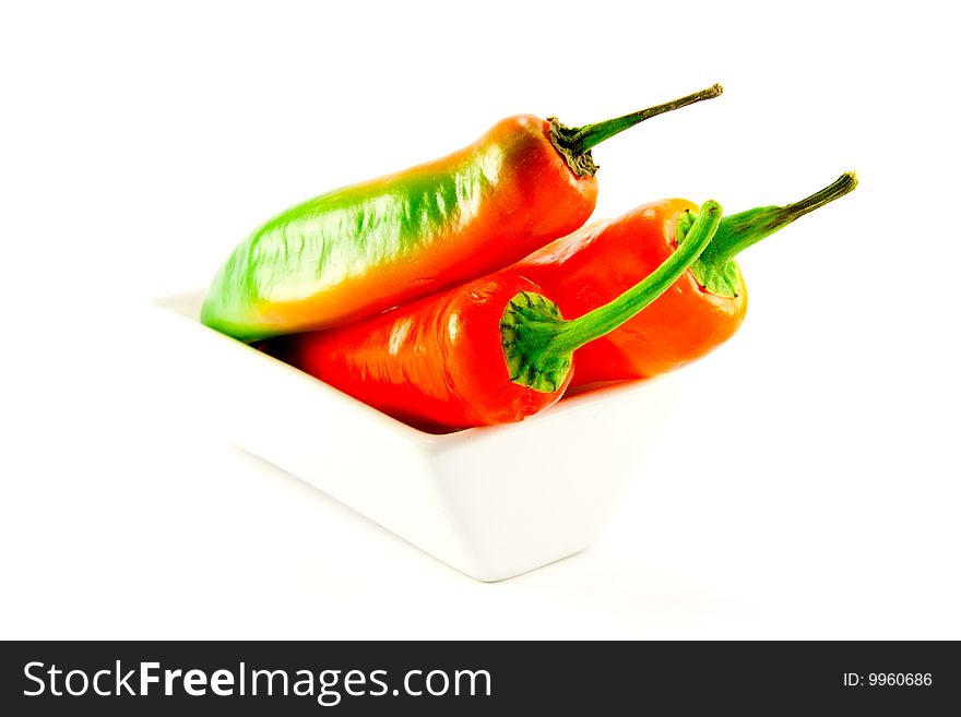 Assorted whole chillis in a square bowl with clipping path on a white background. Assorted whole chillis in a square bowl with clipping path on a white background
