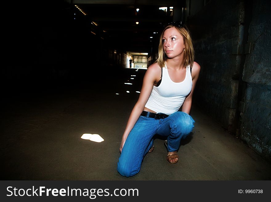 Beautiful girl sits in the dark tunnel. Beautiful girl sits in the dark tunnel