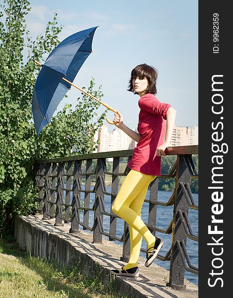 Bright fashionable girl with the umbrella in the sunlight on nature. Bright fashionable girl with the umbrella in the sunlight on nature.