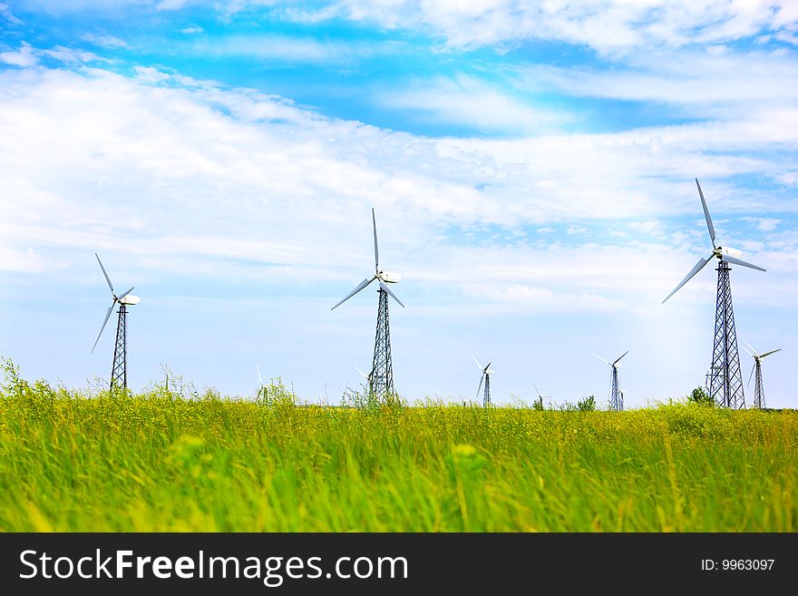 Power generating wind turbines on a green field. Power generating wind turbines on a green field