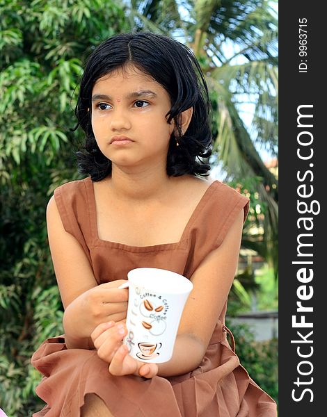 A nice Indian girl having some serious thoughts while having a morning coffee. A nice Indian girl having some serious thoughts while having a morning coffee.