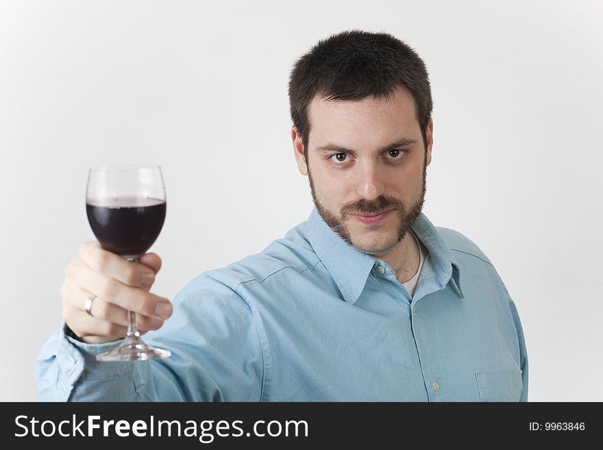 Young, handsome man, holding a glass of wine up in his hand, toasting. Young, handsome man, holding a glass of wine up in his hand, toasting