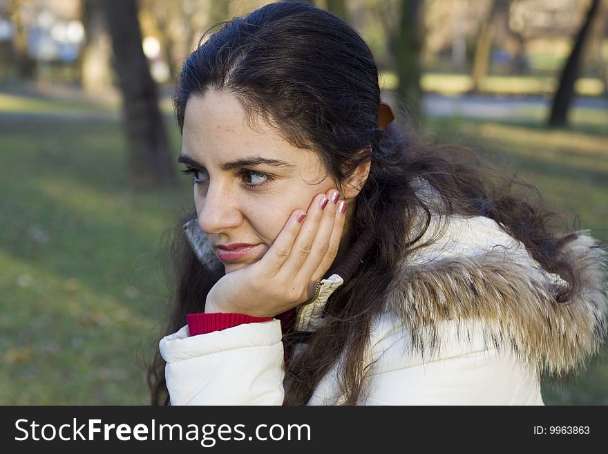 Young, beautiful woman, sitting on the bench in the park, thinking. Young, beautiful woman, sitting on the bench in the park, thinking