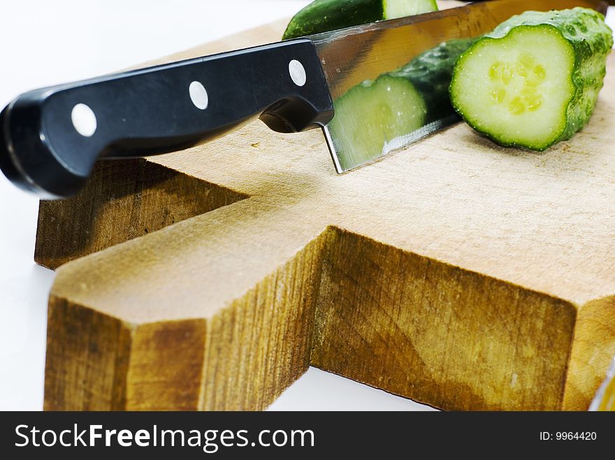 Kitchen knife and green cucumber on wood table