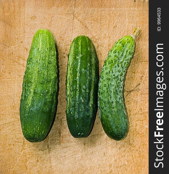Three green cucumber on wood table with selective focus. Three green cucumber on wood table with selective focus