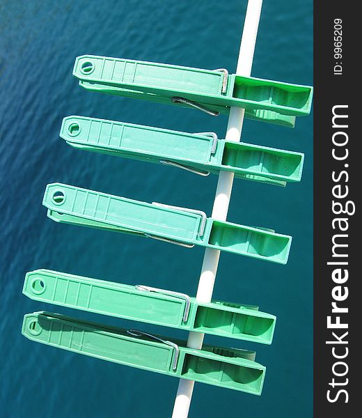 Five green clothespins at a line