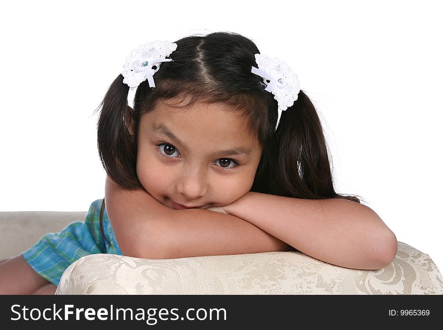 Pretty girl in blue dress resting on arm of couch. Pretty girl in blue dress resting on arm of couch