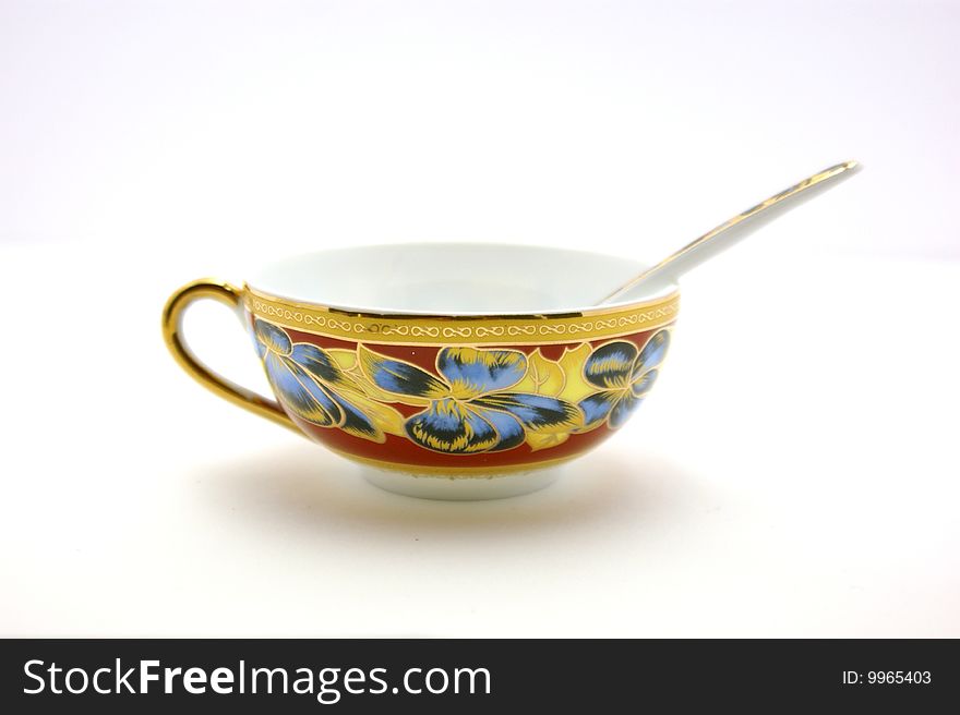 Cup with a picture on a white background. beautiful spoon in the cup. Cup with a picture on a white background. beautiful spoon in the cup