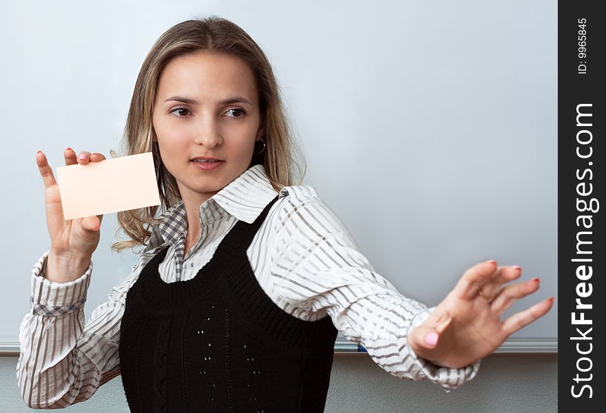 Making look younger beautiful girl beside boards shows orange card. Making look younger beautiful girl beside boards shows orange card