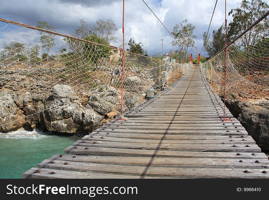 Old wooden hanging bridge over a bay in the coast