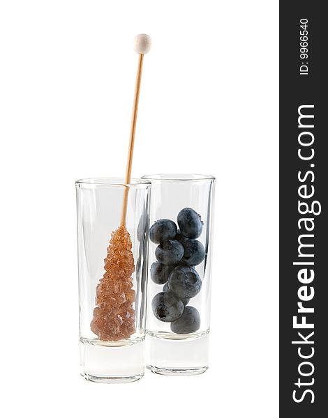 Rock sugar and huckleberries in glass, isolated on white background