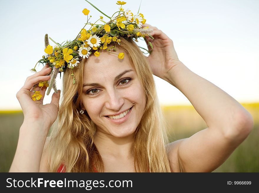A portrait of a pretty girl in a chaplet of summer flowers