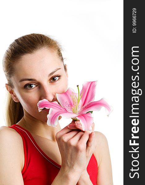 A portrait of a nice blond girl in red with a pink lily near her face on a white background. A portrait of a nice blond girl in red with a pink lily near her face on a white background