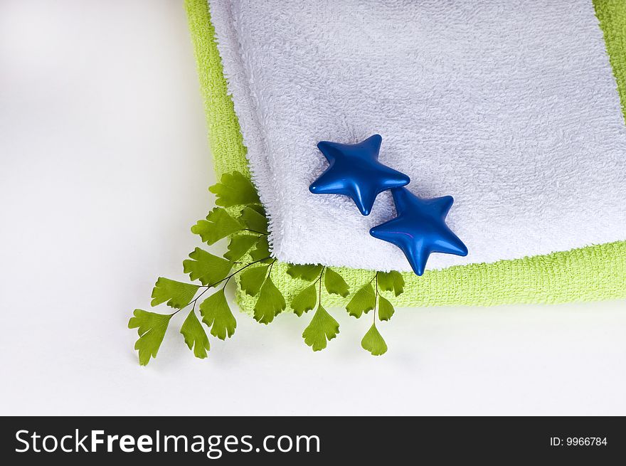 Well being concept with towel, bath-oil capsules and plants on white background. Well being concept with towel, bath-oil capsules and plants on white background